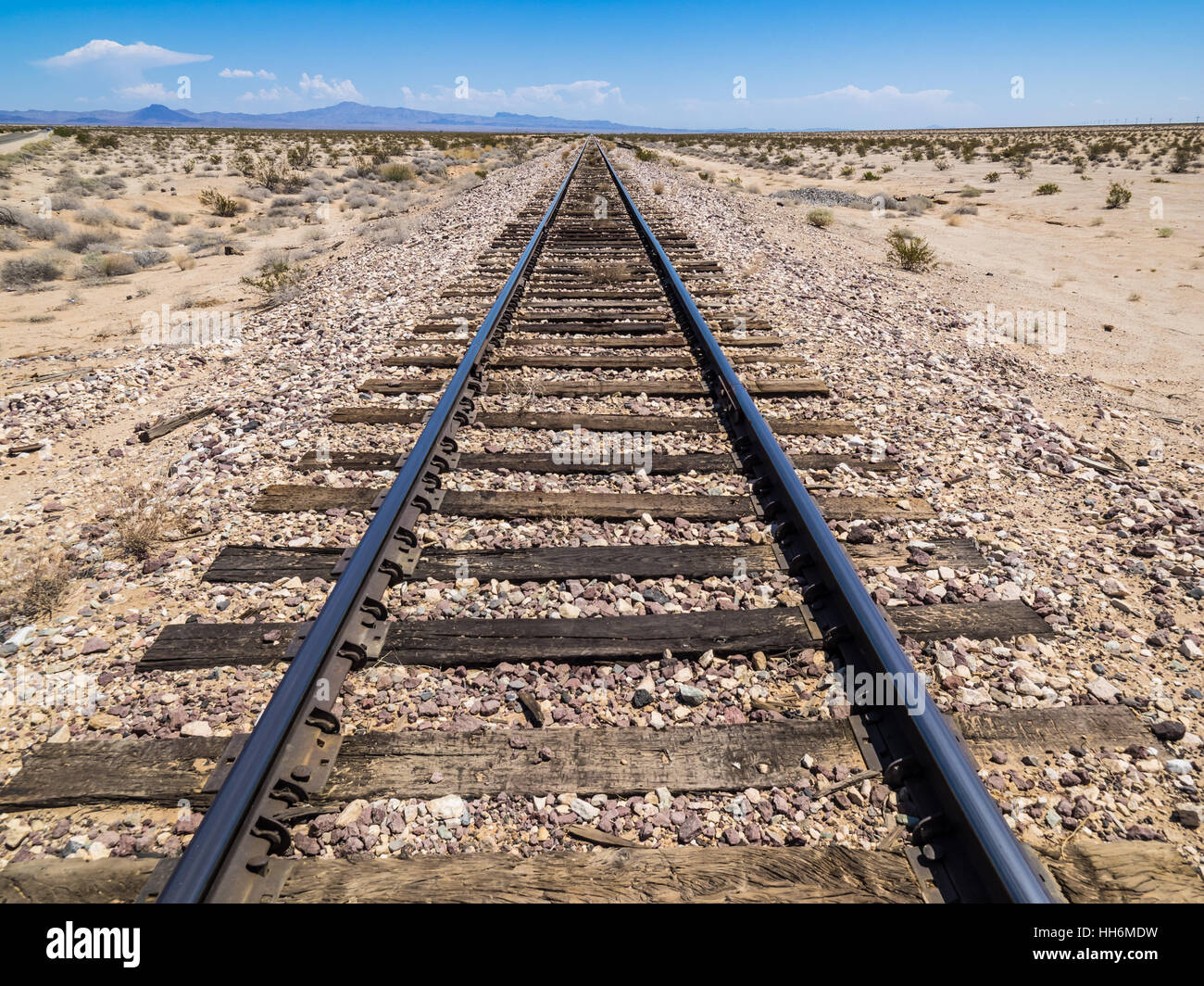 Linee ferroviarie convergenti in distanza, il deserto californiano Foto Stock