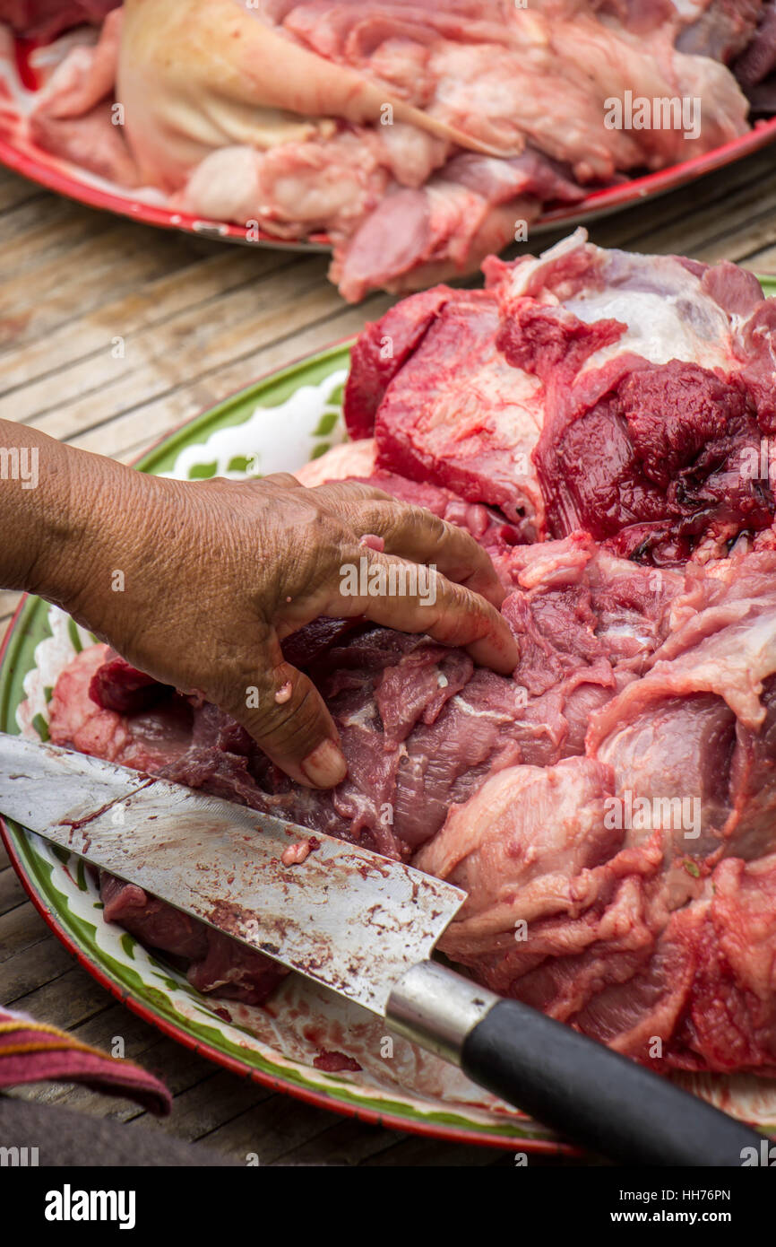 Donna a mano nella cucina cucina arrosto di maiale: taglio di carne. Foto Stock