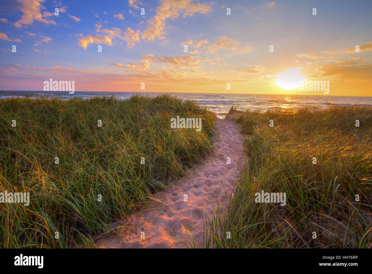 Percorso di un tramonto sulla spiaggia. Sentiero di avvolgimento attraverso dune erba conduce ad un Sunset Beach sulla costa del mare interno del Lago Michigan Foto Stock