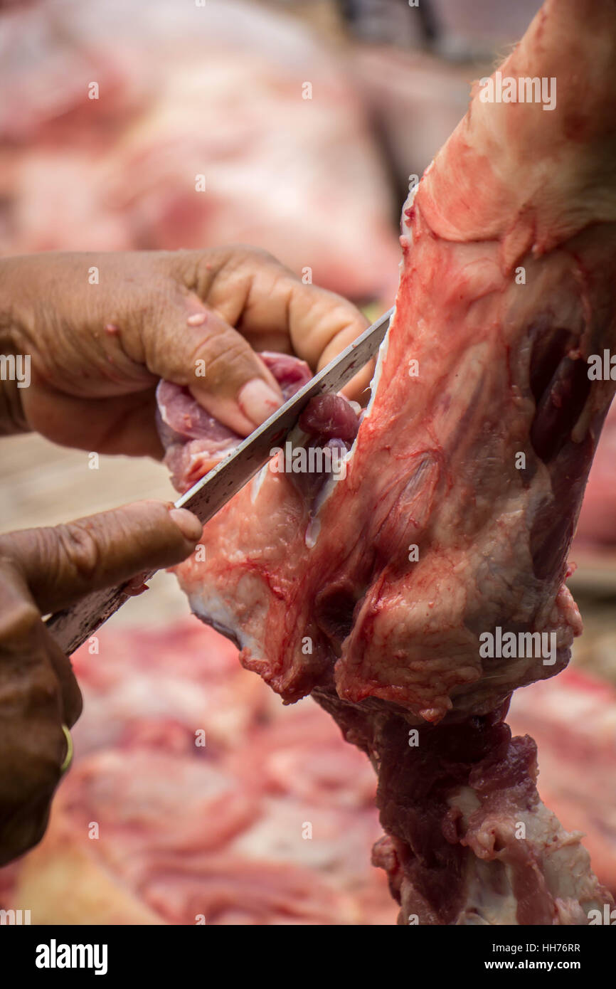 Donna a mano nella cucina cucina arrosto di maiale: taglio di carne. Foto Stock