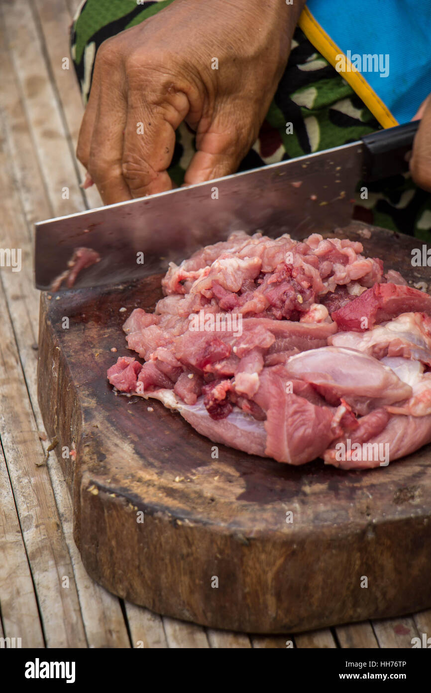 Donna a mano nella cucina cucina arrosto di maiale: taglio di carne. Foto Stock
