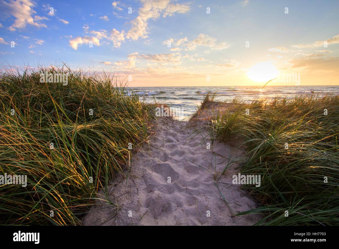 Percorso di un estate Sunset Beach. Spiaggia sabbiosa sentiero conduce a una soleggiata estate orizzonte su acque aperte del lago Michigan. Hoffmast Foto Stock