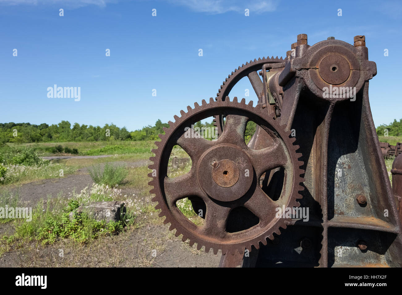 Arrugginimento delle attrezzature industriali con gli ingranaggi. Parte di una miniera di rame abbandonata. Foto Stock