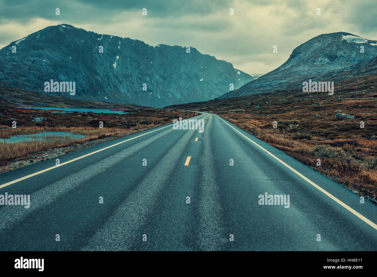 Prospettiva di strada nella cortina di nubi meteo. Norvegia paesaggio. Lo stile del film drammatico di colori. Foto Stock