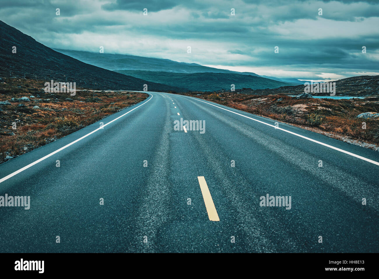 Prospettiva di strada nella cortina di nubi meteo. Norvegia paesaggio. Lo stile del film drammatico di colori. Foto Stock