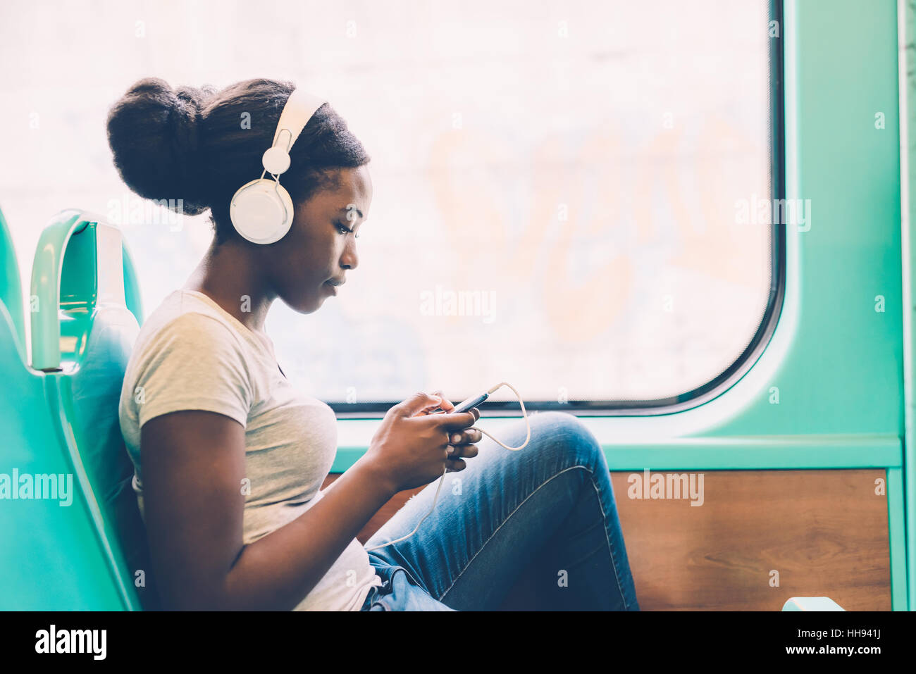 Giovane donna nera ascoltare musica in viaggio in autobus utilizzando smart  phone tenere in mano, pensieroso - riflessivo, pensare futuro, il concetto  di musica Foto stock - Alamy