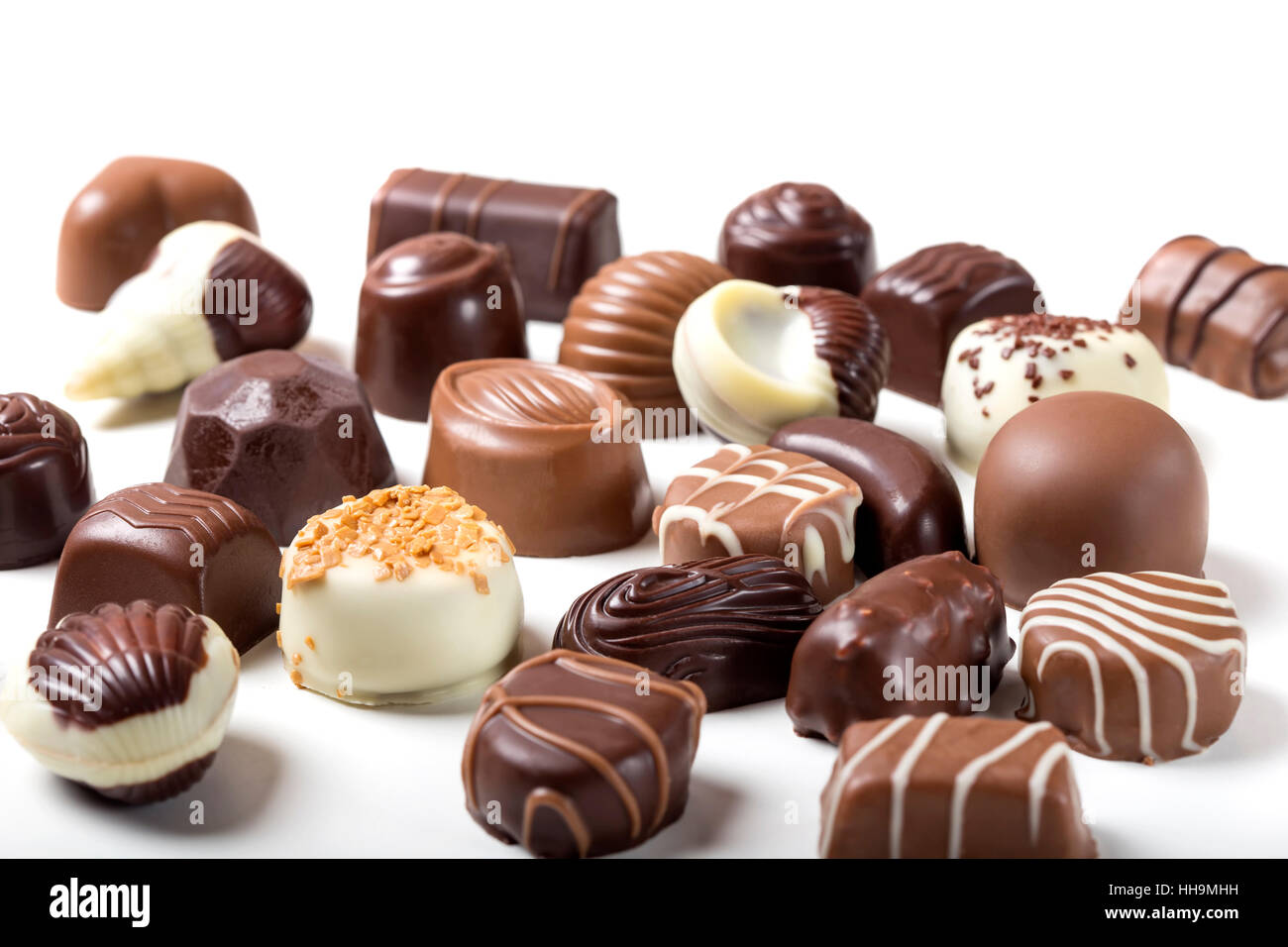 Assortimento di raffinati cioccolatini, bianco, scuro e cioccolato al latte su sfondo bianco Foto Stock