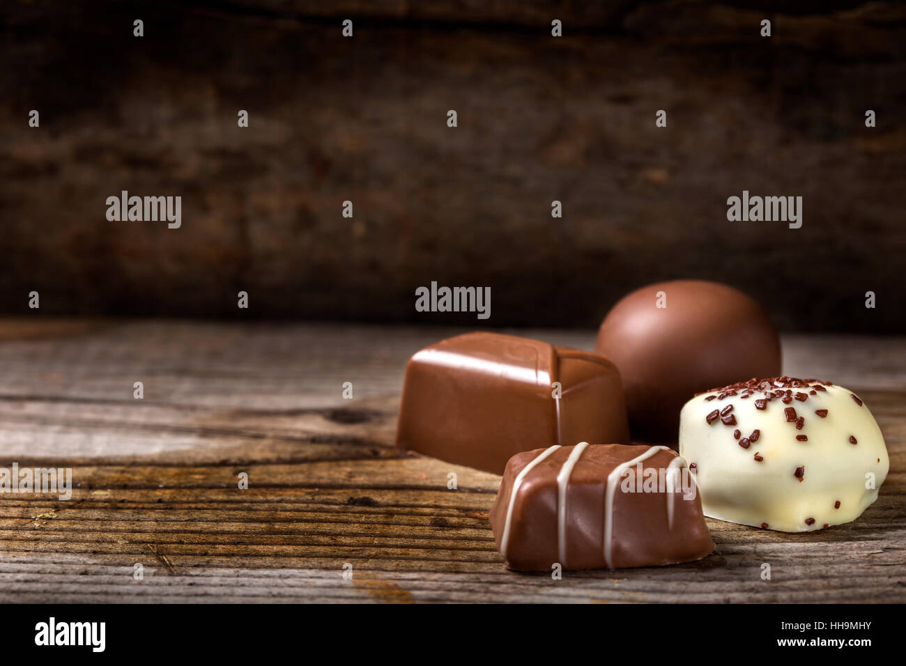 Quattro diversi tipi di cioccolato candy oltre rustico sfondo di legno Foto Stock