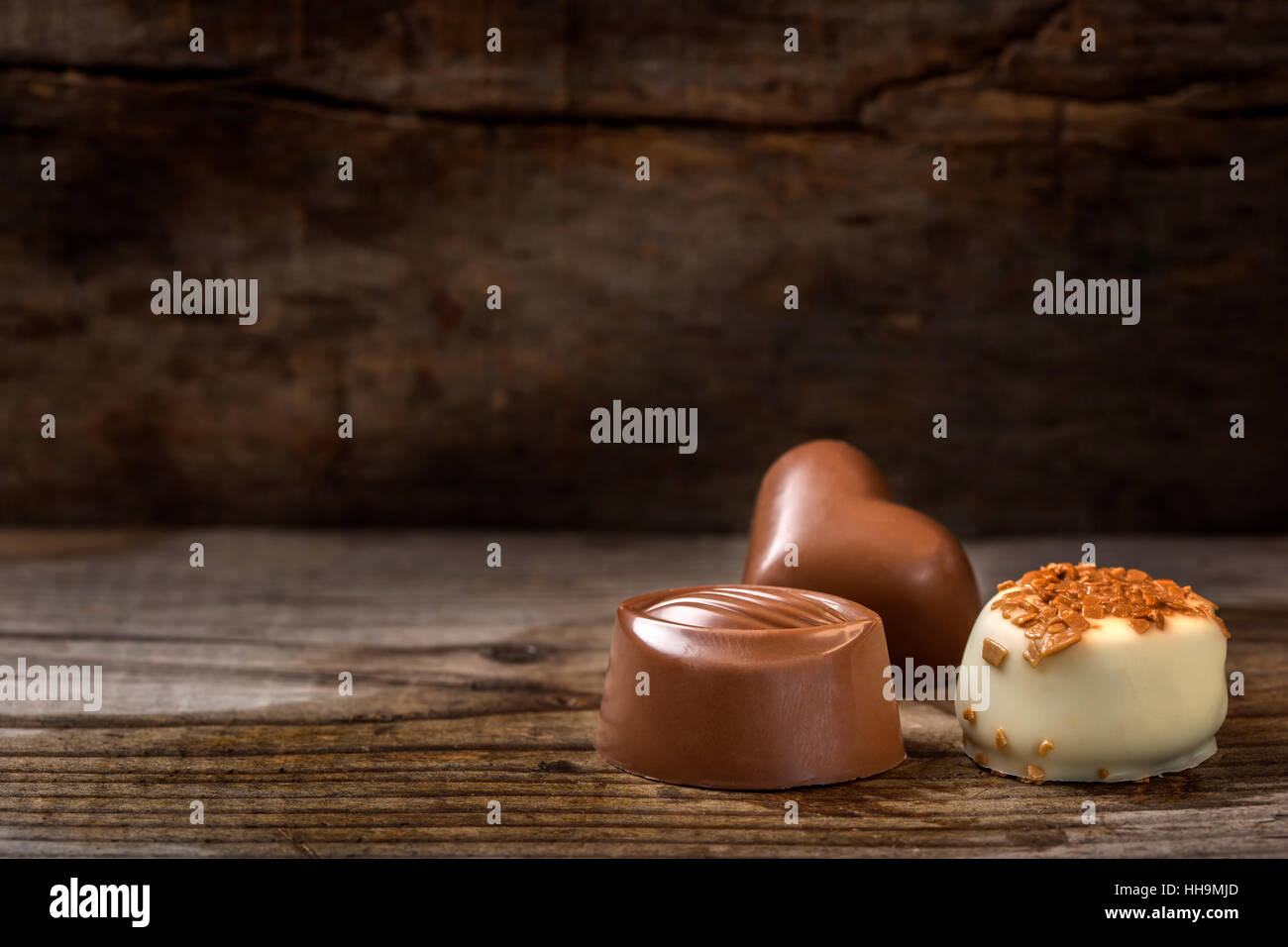 Tre diversi tipi di cioccolato candy oltre rustico sfondo di legno Foto Stock