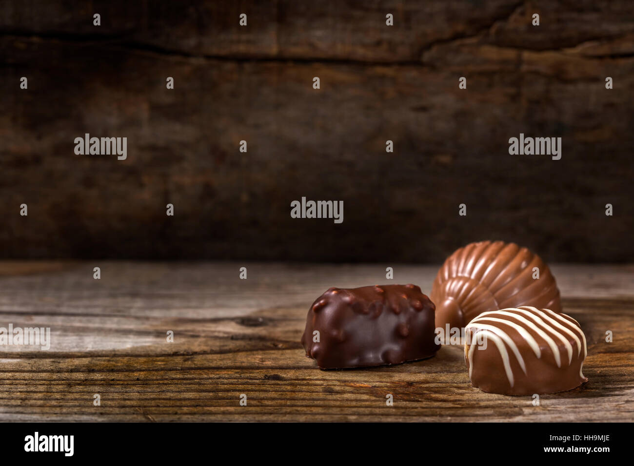 Tre diversi tipi di cioccolato candy oltre rustico sfondo di legno Foto Stock