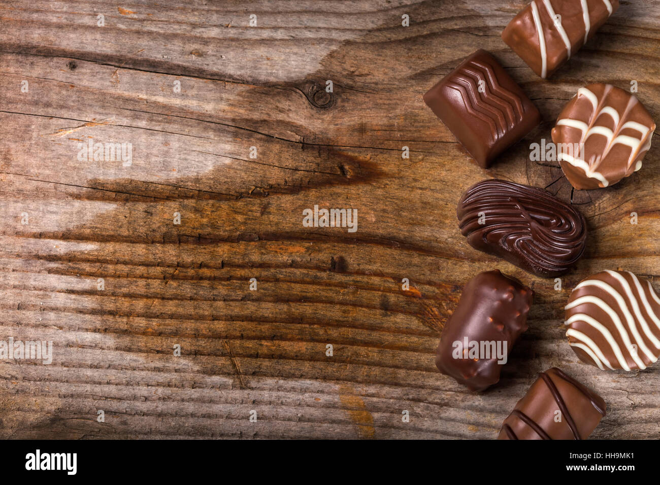 Tipi di cioccolato differenti candy su legno rustico sfondo con spazio di copia Foto Stock