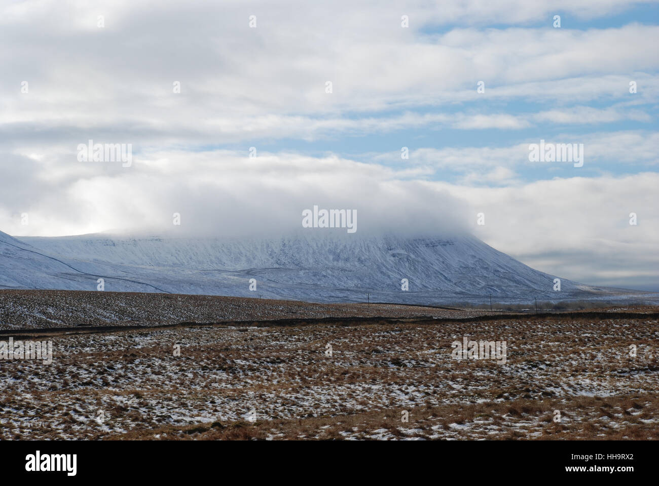 Bassa nuvola scorre sopra la collina di una neve coperta Inglevborough in inverno Foto Stock