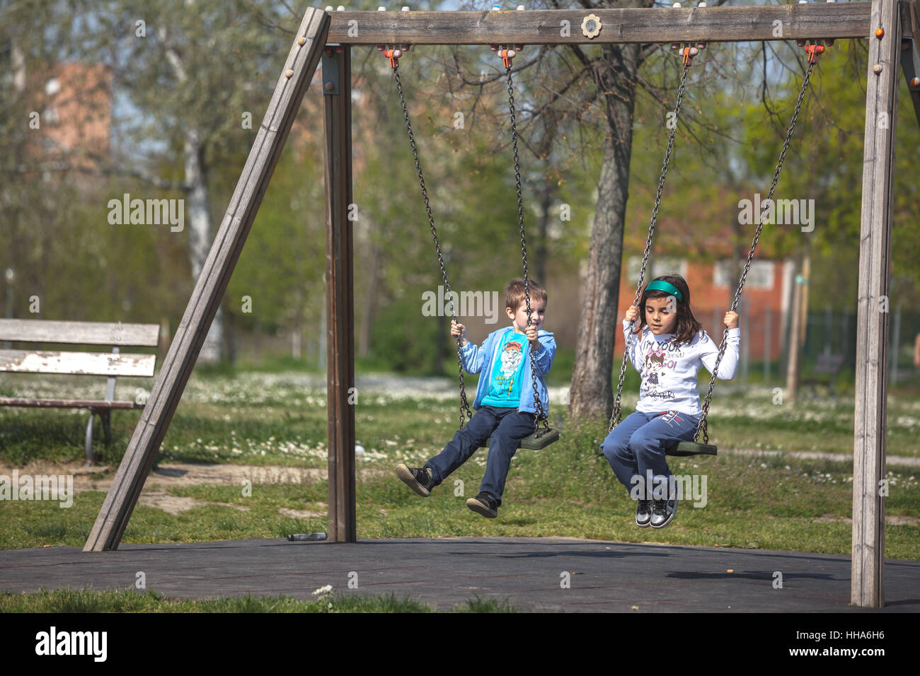 2 bambini un ragazzo e una ragazza su una conversazione di oscillazione Foto Stock