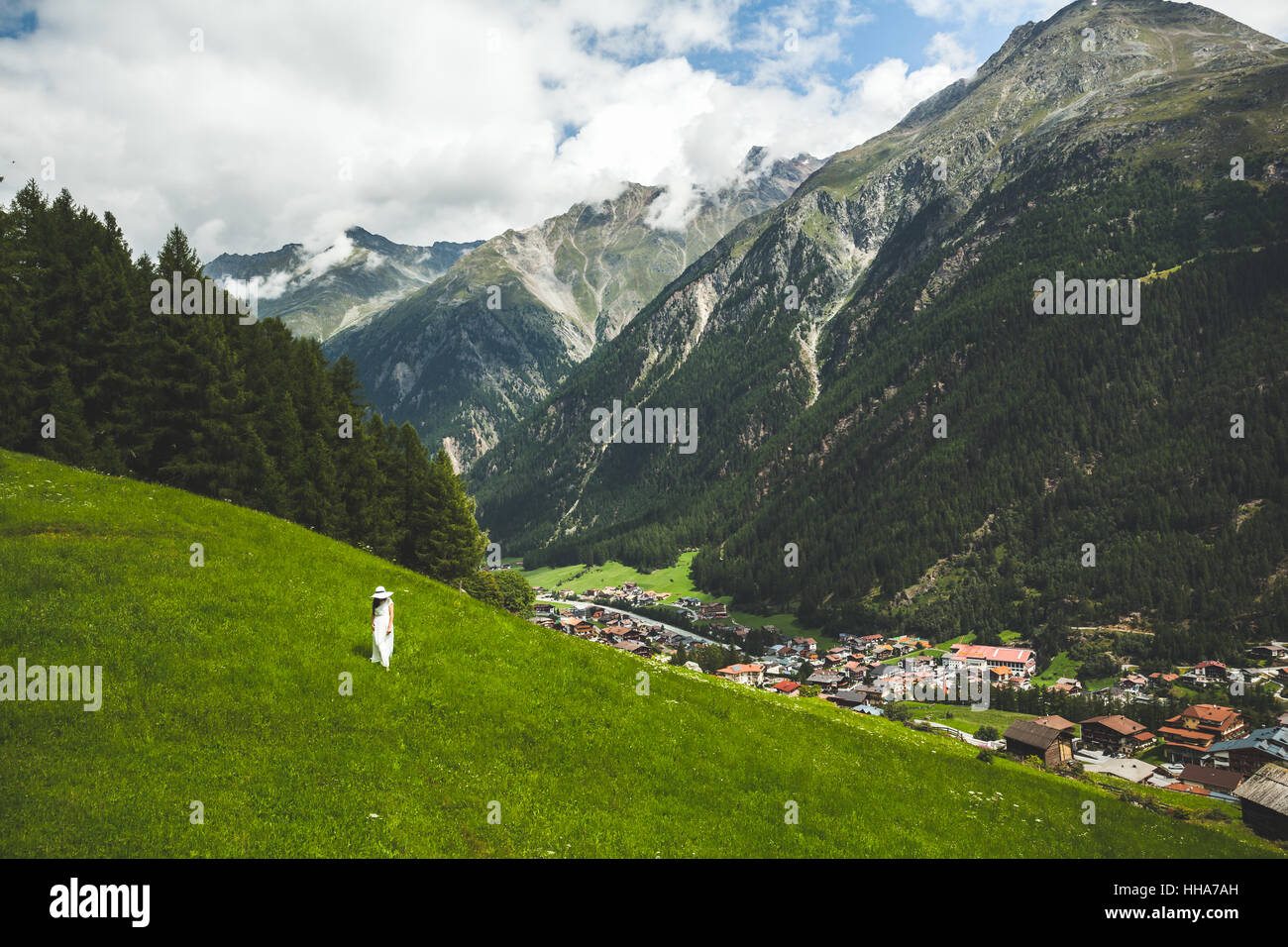 Giovane donna in abito bianco e cappello da solo camminando sulla montagna altopiano in Solden Austria Foto Stock