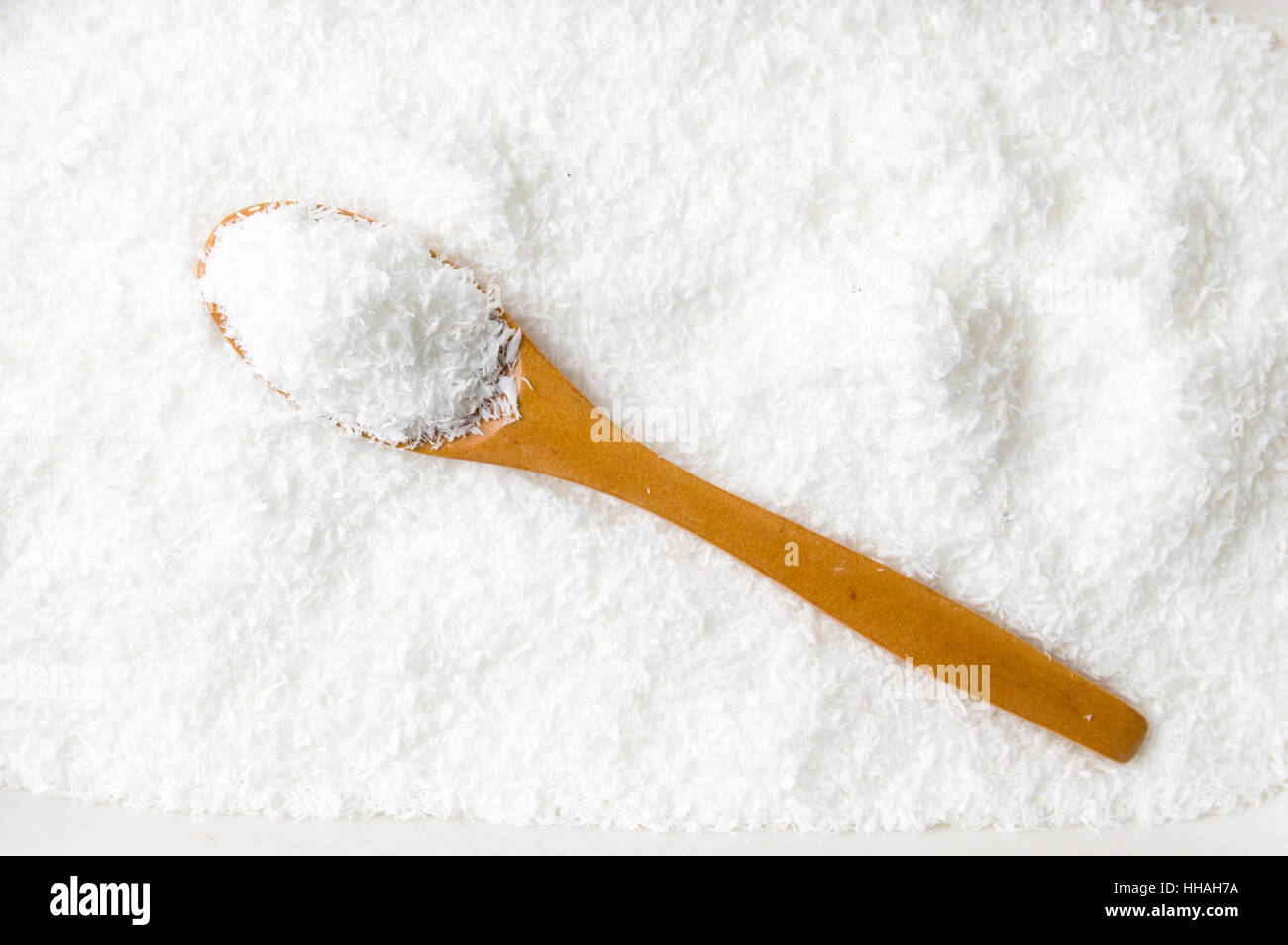 Polvere di noce di cocco e un intero cucchiaio di legno sulla parte superiore Foto Stock