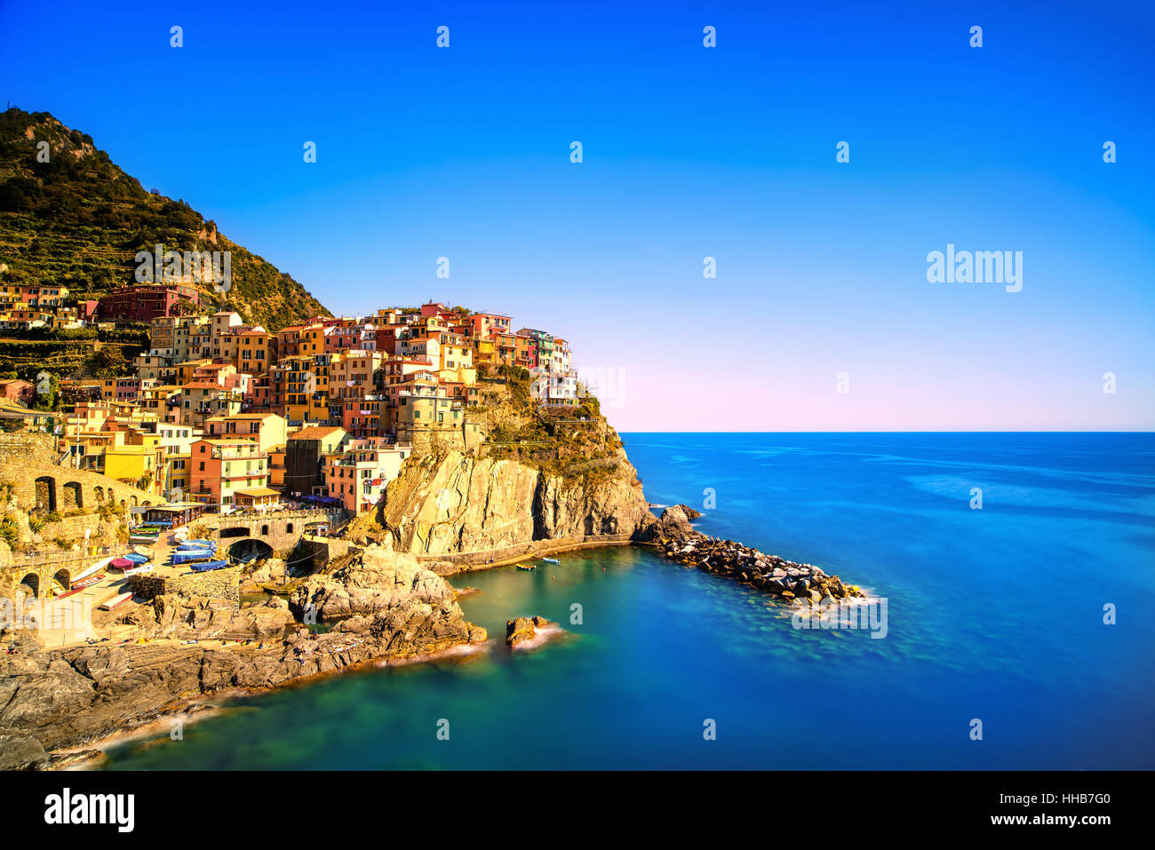 Manarola village sulla scogliera di rocce e mare al tramonto., Seascape in cinque terre, il Parco Nazionale delle Cinque Terre Liguria Italia Europa. Formato quadrato. Lunga Expo Foto Stock