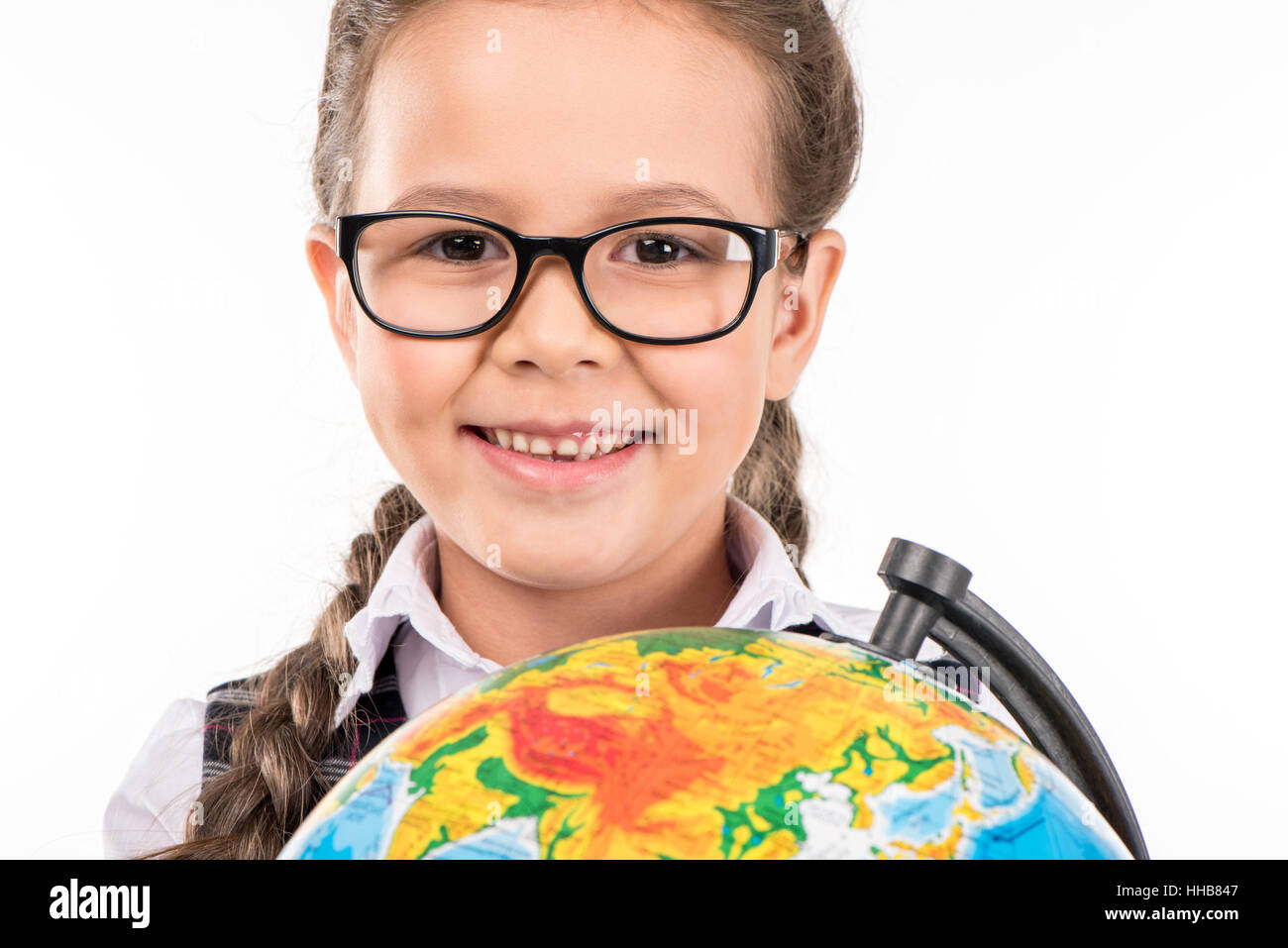Ritratto di schoolgirl sorridente in telecamera con globo in mani isolato su bianco Foto Stock