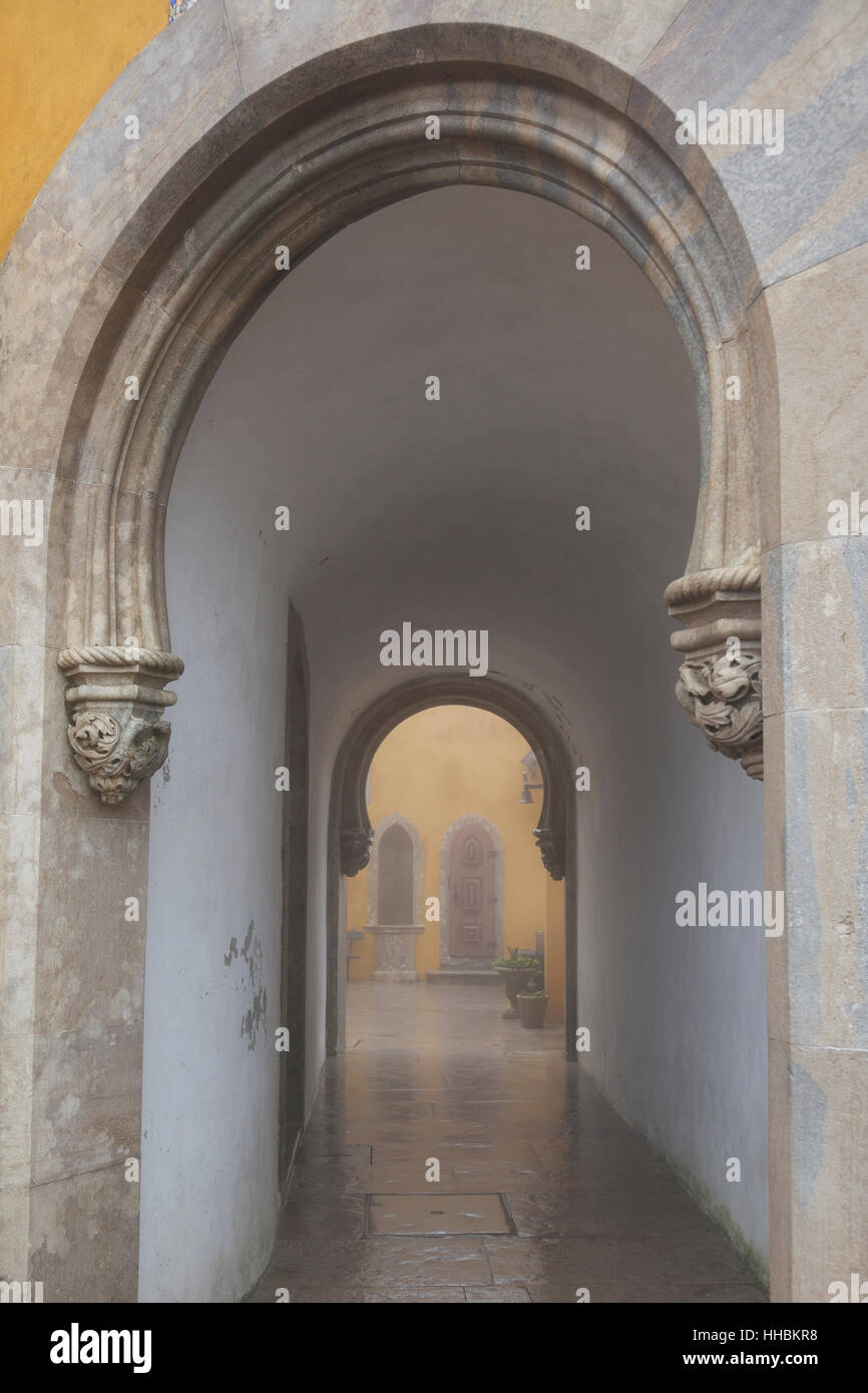 Sintra, Portogallo: Ferro di Cavallo passaggio arcuato in una mattinata nebbiosa a pena Palace. Foto Stock