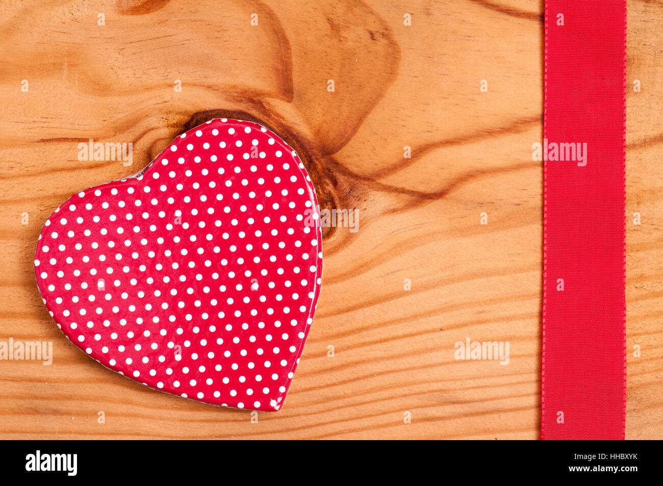 Cuore rosso con puntini bianchi e nastro rosso Foto Stock