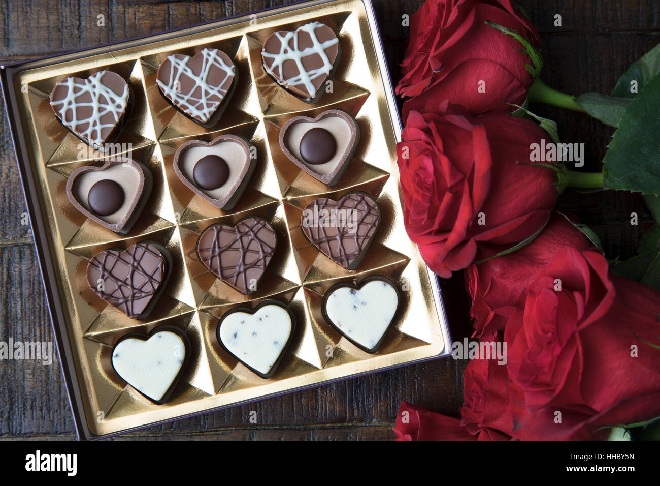 Scatola di romantico a forma di cuore i cioccolatini e rose rosse. Foto Stock