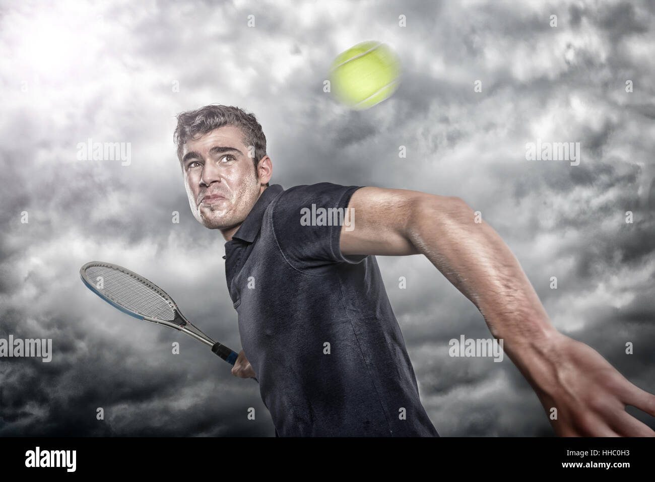 Junger Tennisspieler vor dramatischem Himmel Foto Stock