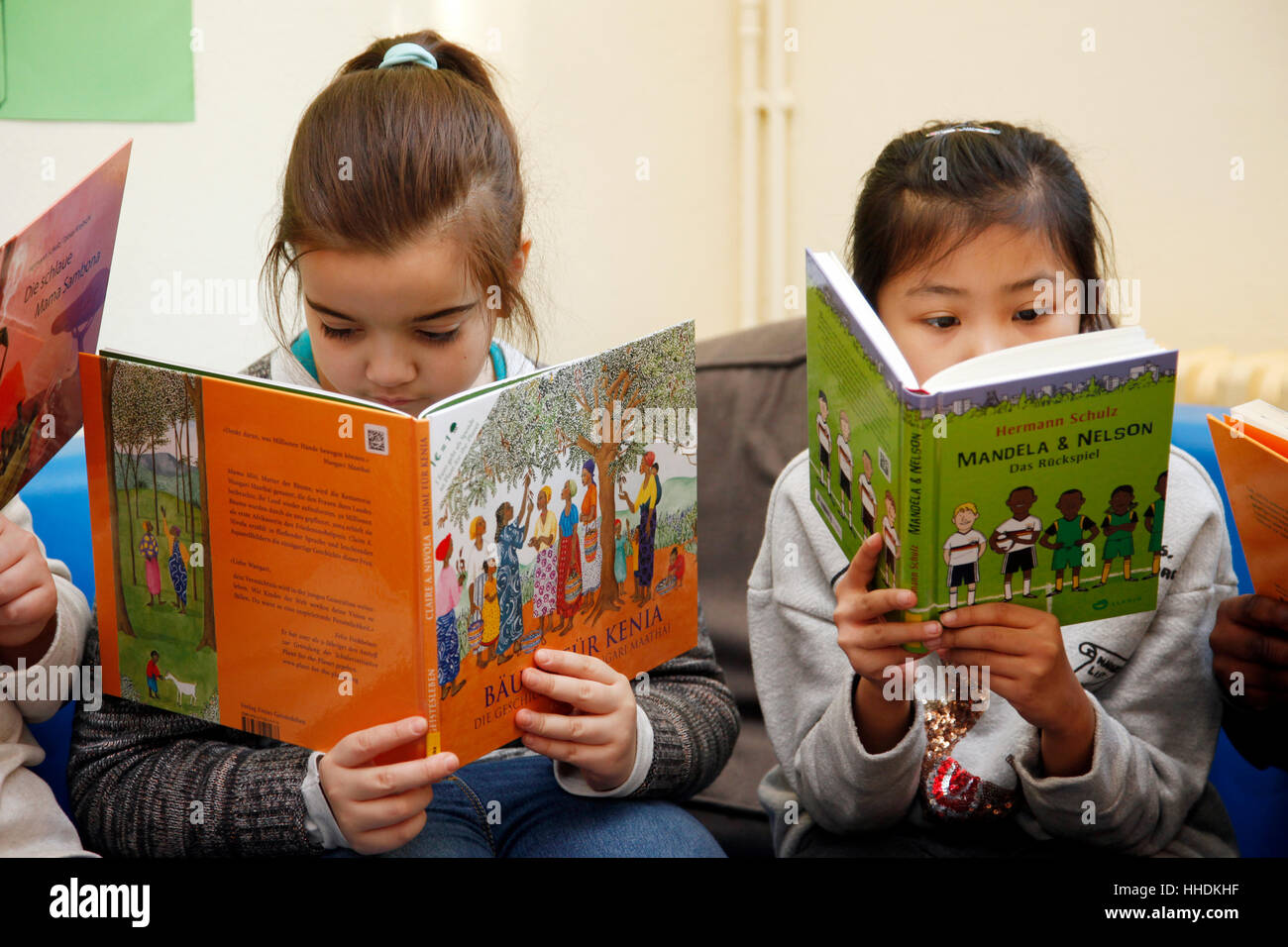 Alunni di una scuola primaria di leggere libri su live in Africa. Foto Stock