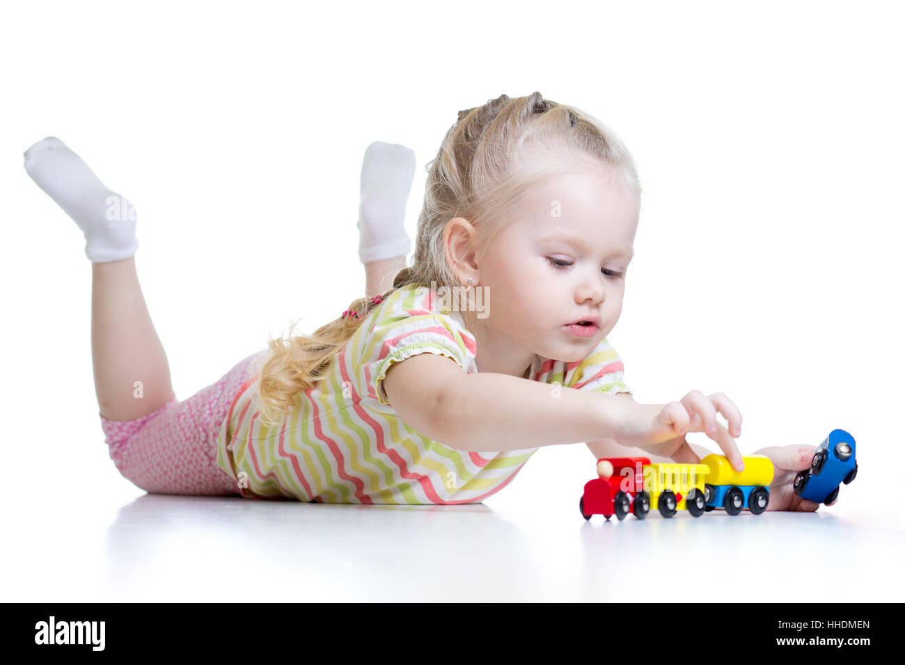 Carino kid bambina giocando treni isolato su bianco Foto Stock