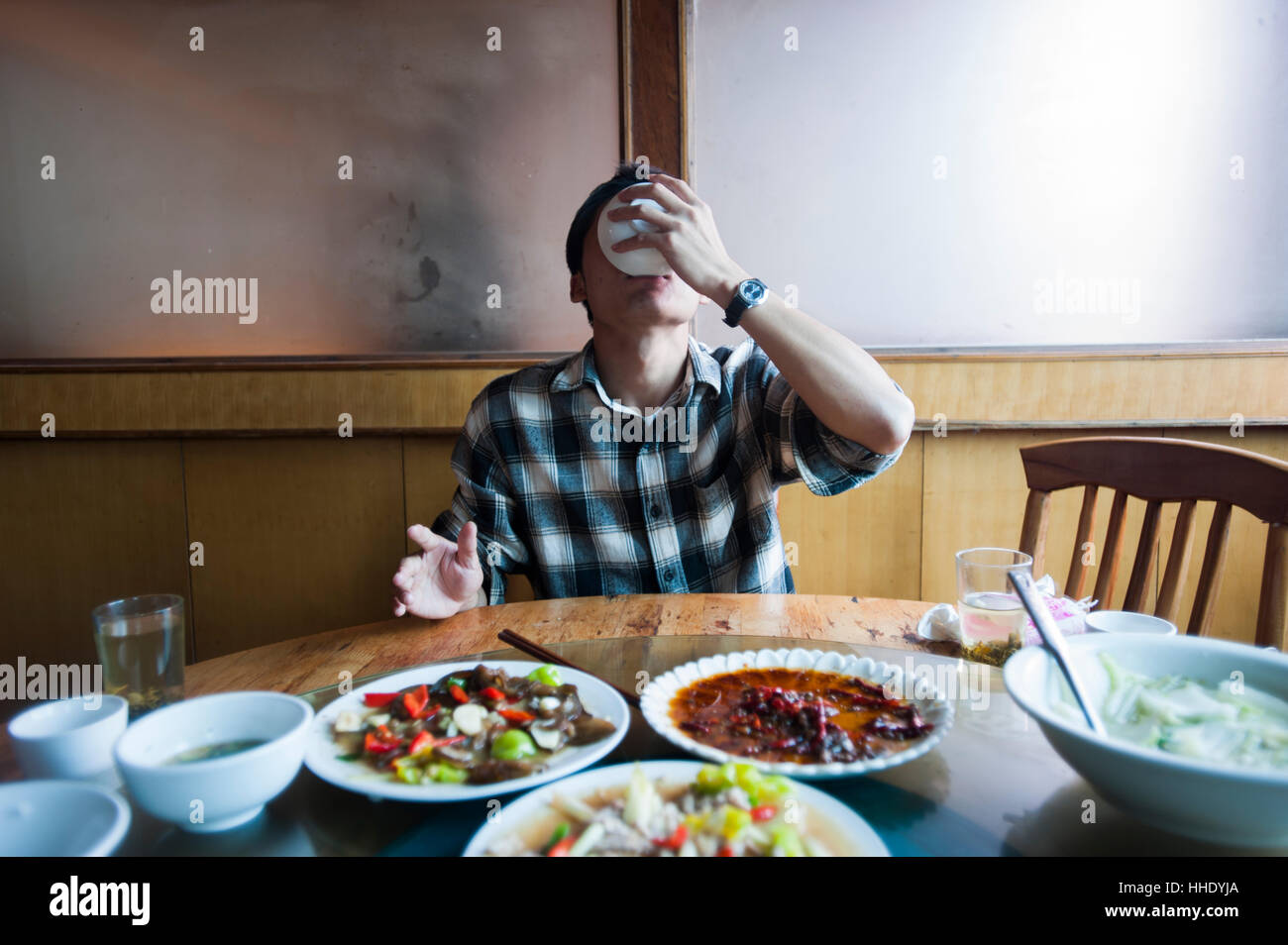 Un uomo finisce la sua zuppa di stile Cinese, nella provincia dello Yunnan in Cina Foto Stock