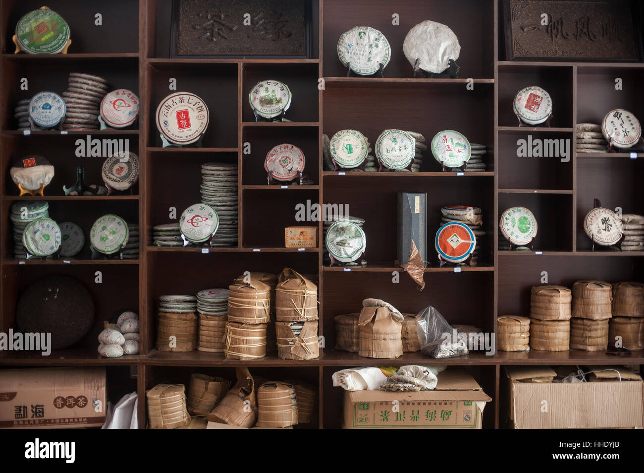 Torte di tè impilate su scaffali in un negozio, Xishuangbanna, nella provincia dello Yunnan in Cina Foto Stock