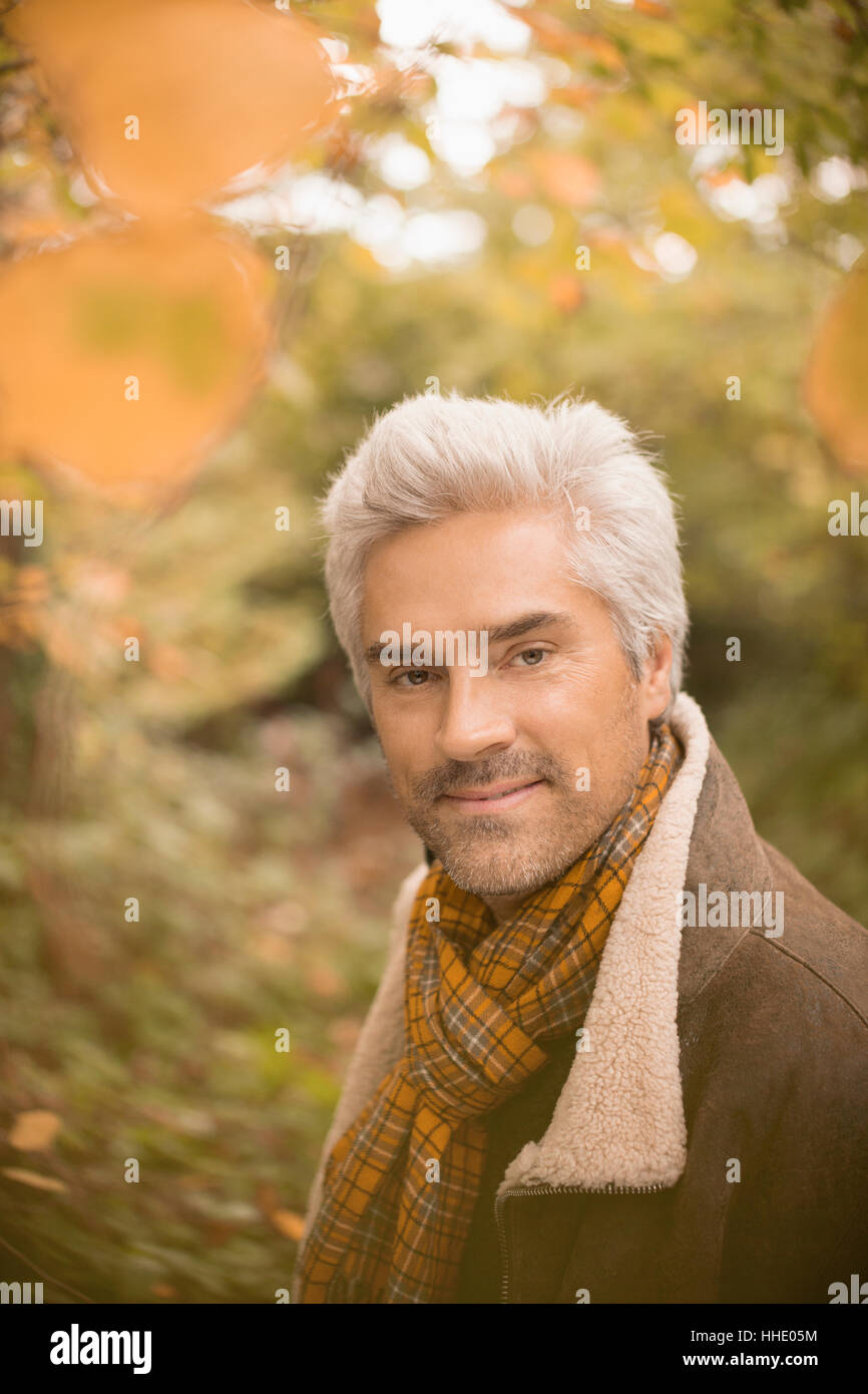 Ritratto fiducioso uomo che indossa una sciarpa in autunno boschi Foto Stock