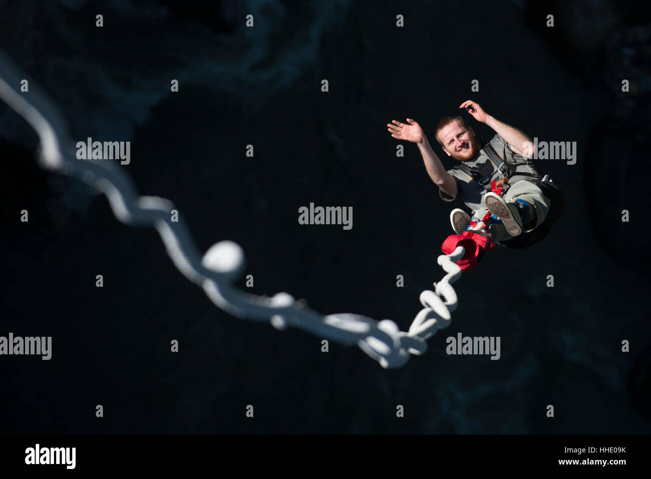 Un uomo sorride per la telecamera come egli è rimbalzato backup durante un bungee jump in ultima istanza, Nepal Foto Stock