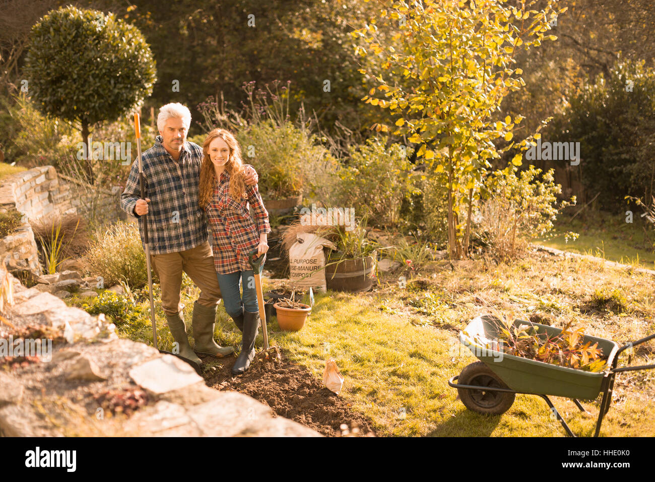 Ritratto sorridente giovane giardinaggio nel soleggiato giardino d'autunno Foto Stock
