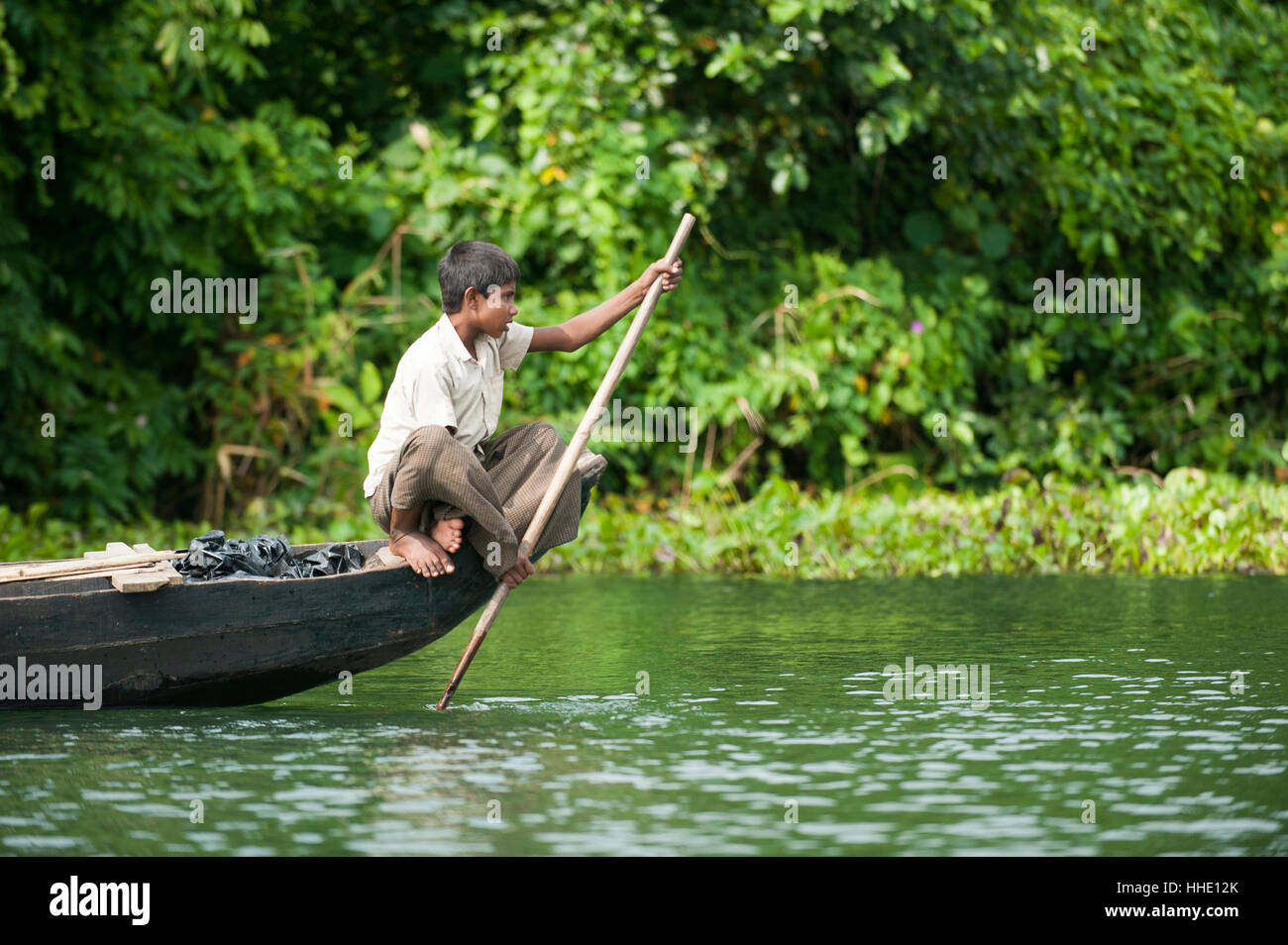 Un ragazzo pagaie attraverso Kaptai lago, Chittagong Hill Tracts, Bangladesh Foto Stock