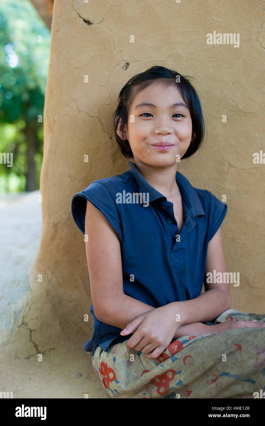 Una ragazza da Rangamati siede al di fuori del suo fango casa murata vicino Kaptai lago, Chittagong Hill Tracts, Bangladesh Foto Stock
