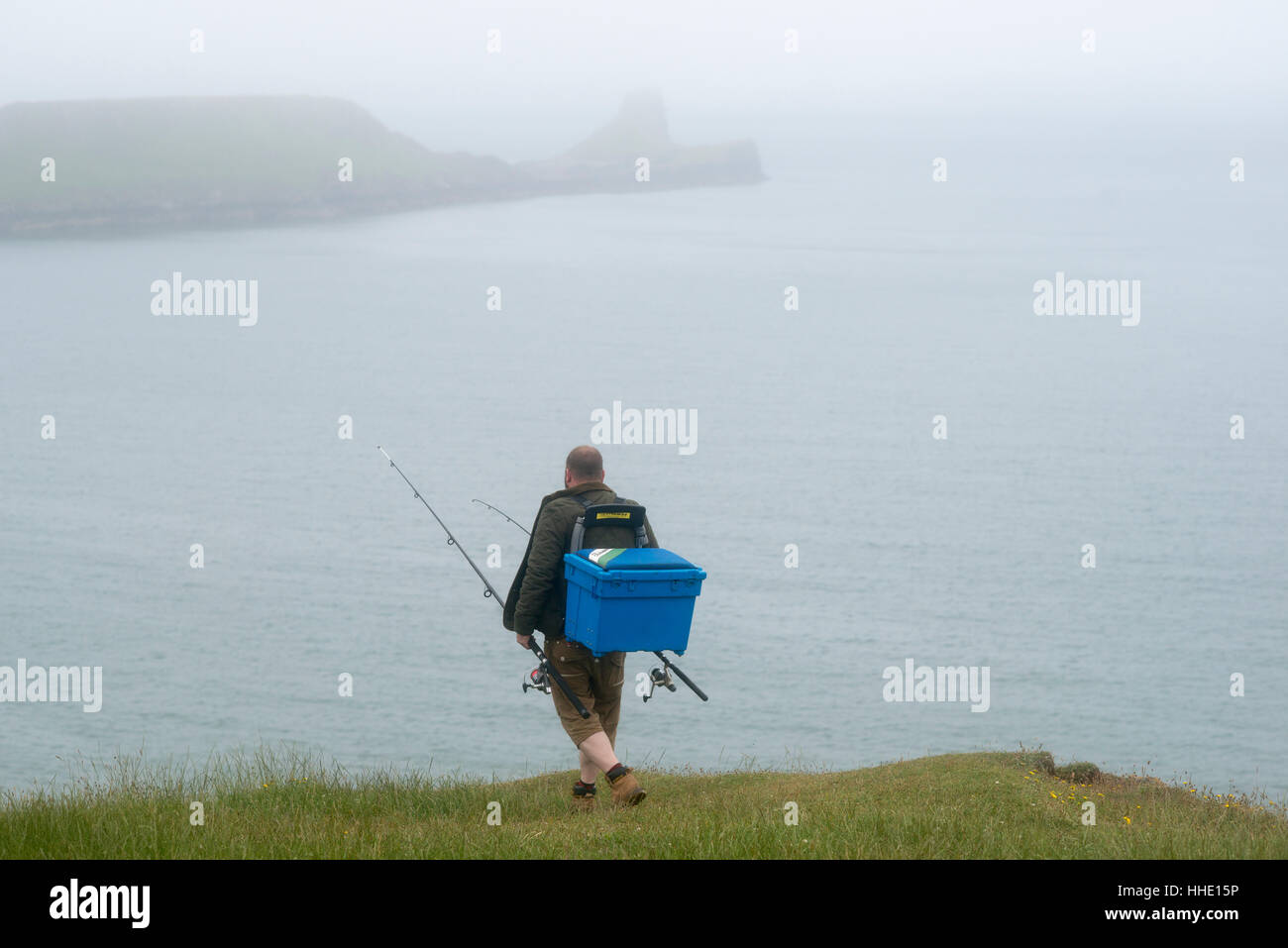 Un pescatore a piedi verso la testa di worm da Rhossili Bay in Gower nel Galles del Sud, Regno Unito Foto Stock