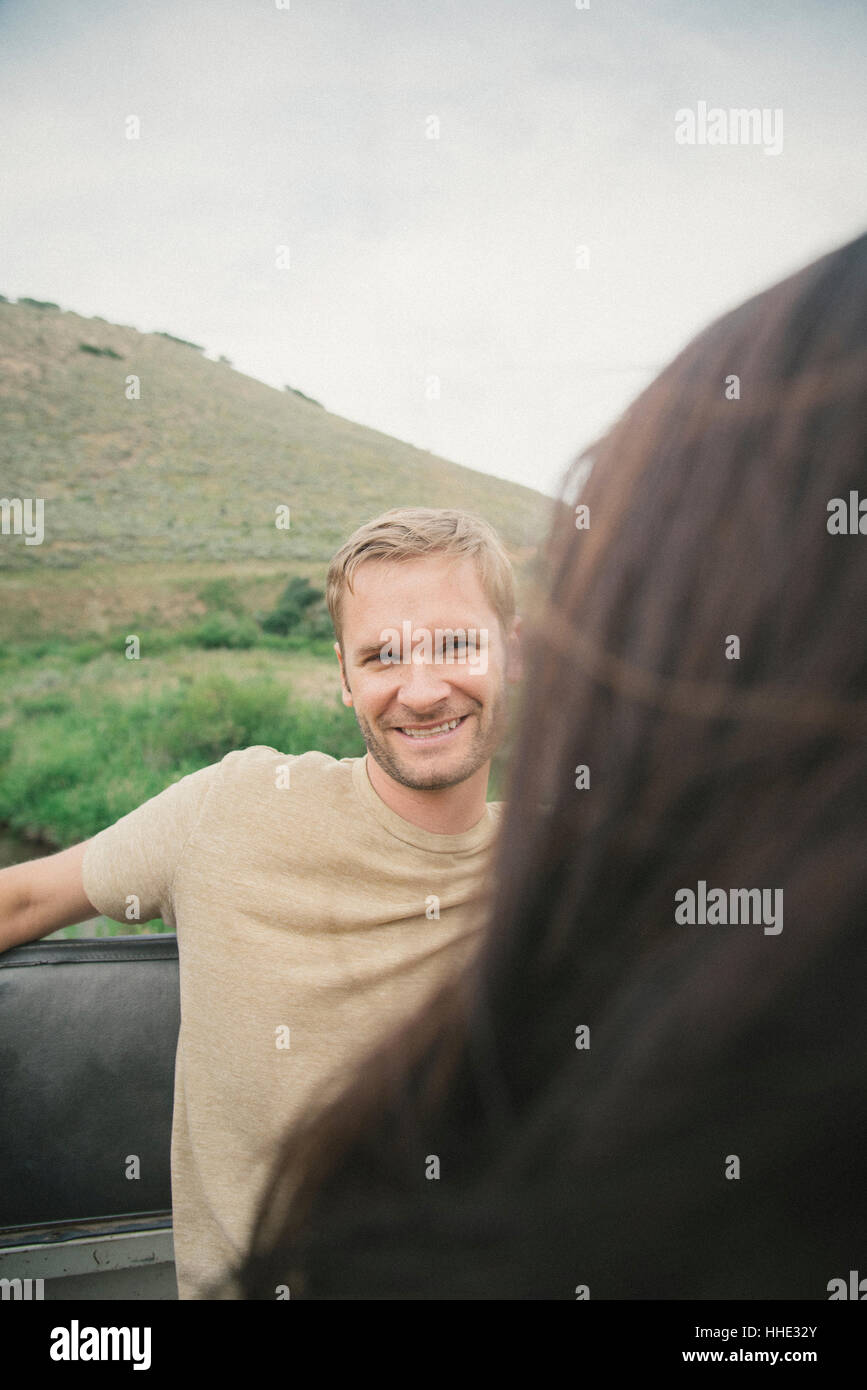 Un giovane su un viaggio in montagna, ridendo. Foto Stock