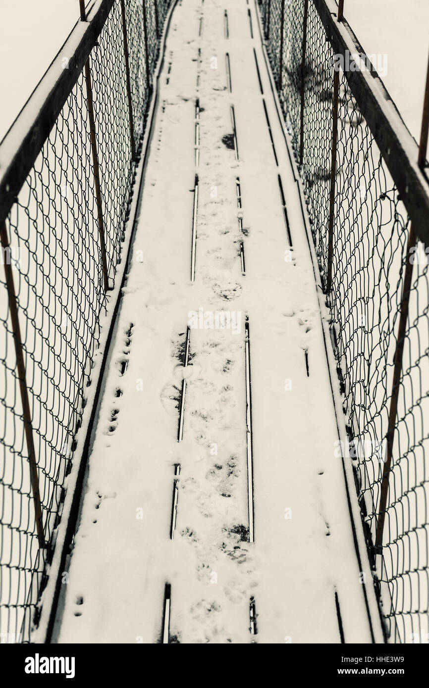 Composizione astratta di un vecchio ponte di sospensione, mountain area d'inverno. Foto Stock