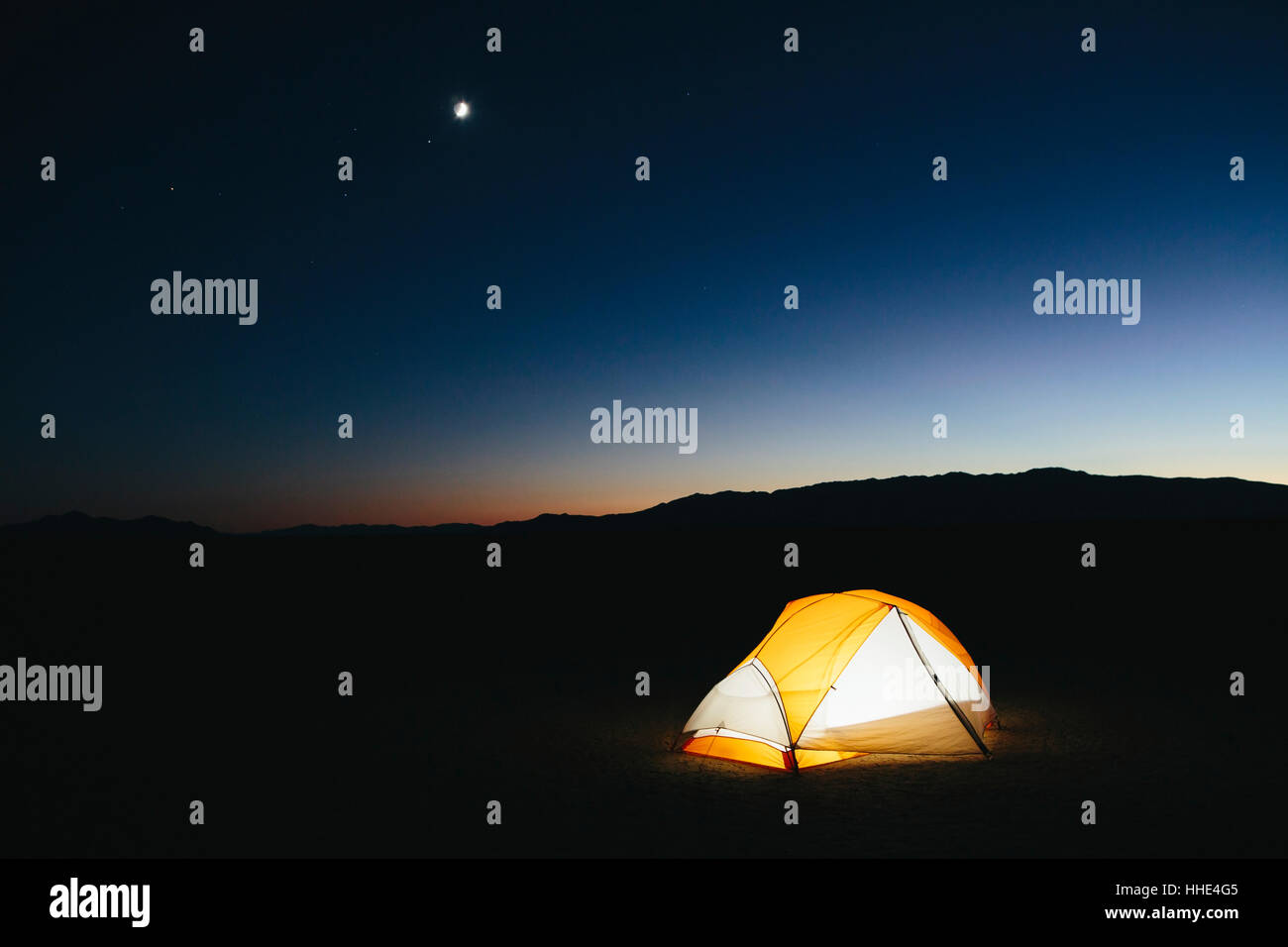 Illuminato tenda da campeggio nel vasto deserto al tramonto, Black Rock Desert, Nevada Foto Stock