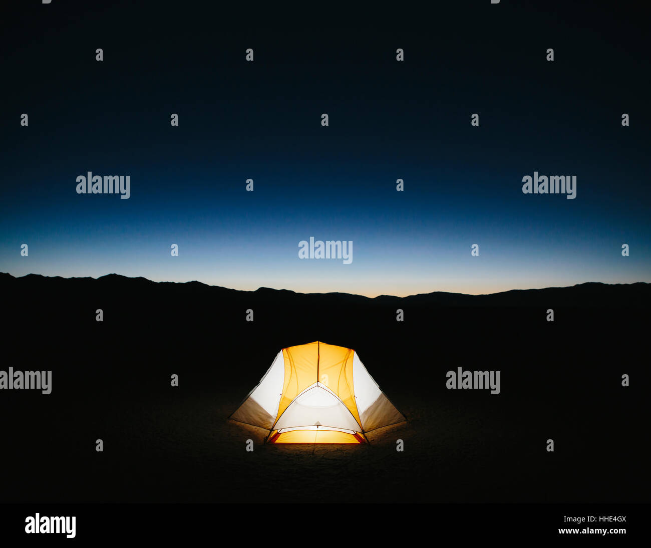 Illuminato tenda da campeggio nel vasto deserto al tramonto, Black Rock Desert, Nevada Foto Stock