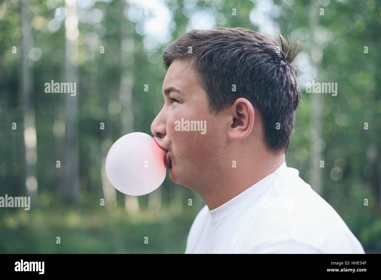 Ritratto di ragazzo adolescente soffiando bubble gum bubble Foto Stock