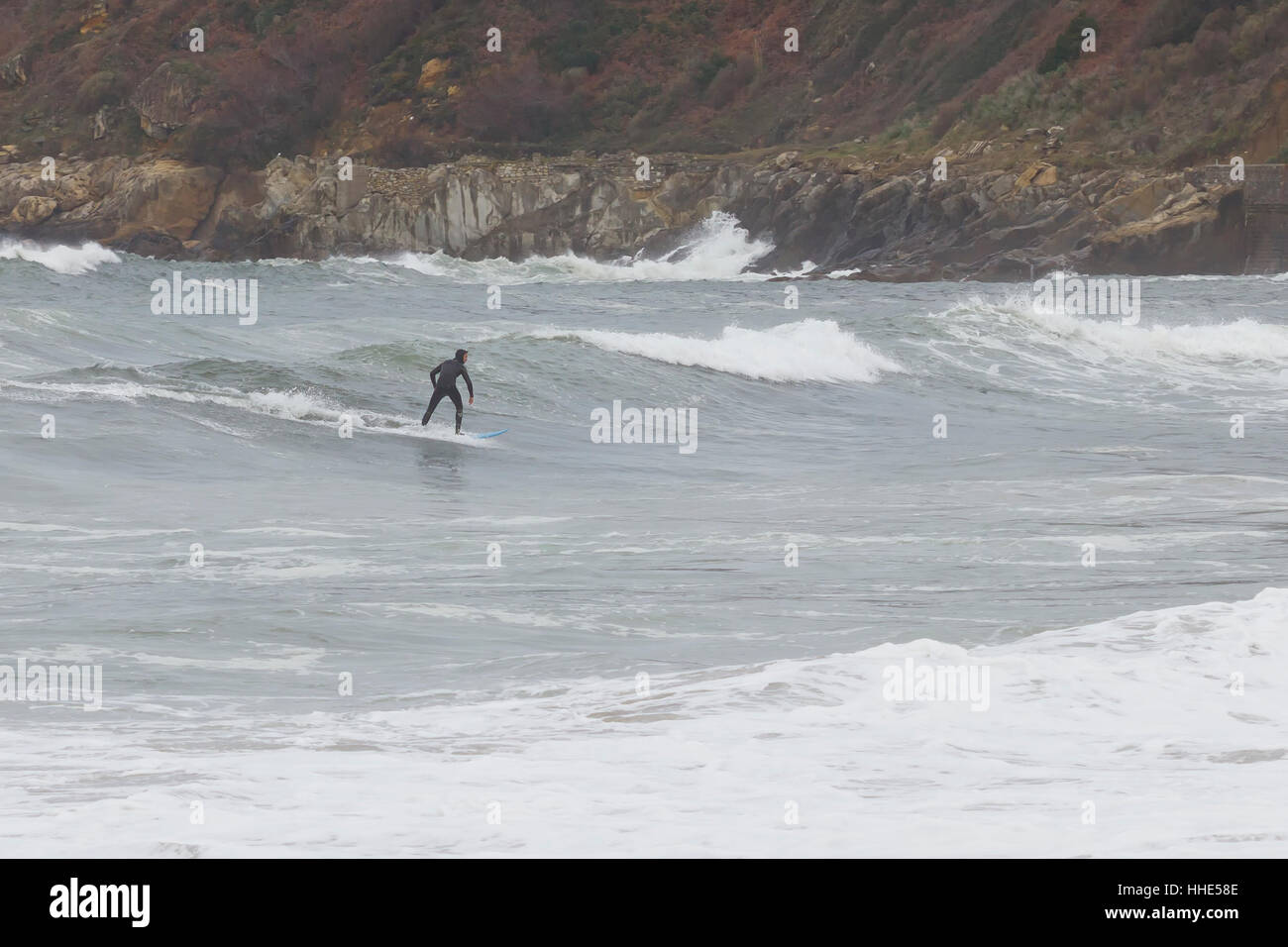 Surfer cattura le onde a riva. Foto Stock