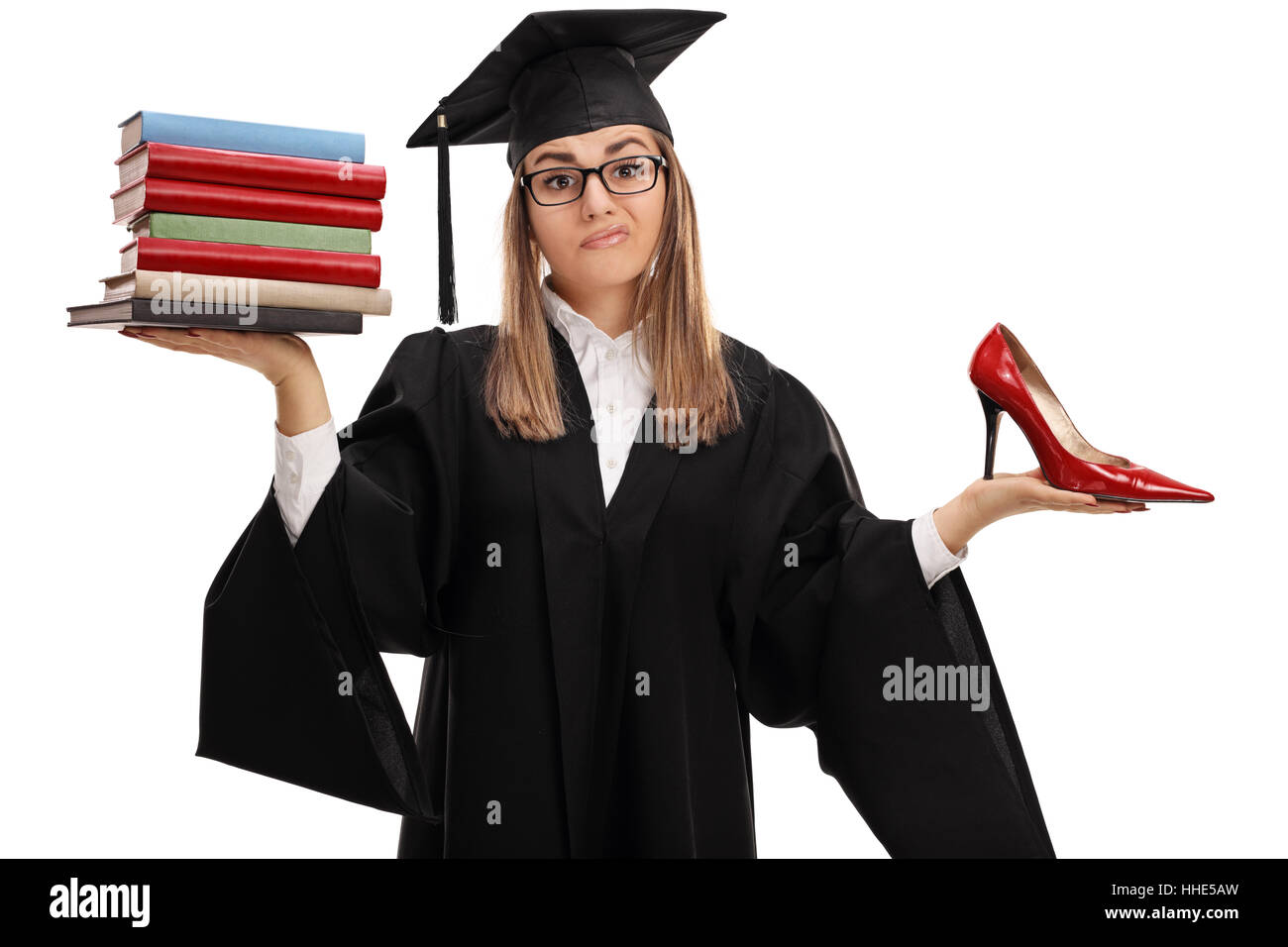 Indeciso studente laureato in possesso di una pila di libri e un tacco alto scarpa isolati su sfondo bianco Foto Stock
