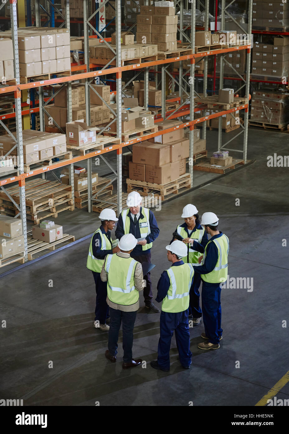 Manager e lavoratori riuniti in circolo nel magazzino di distribuzione Foto Stock