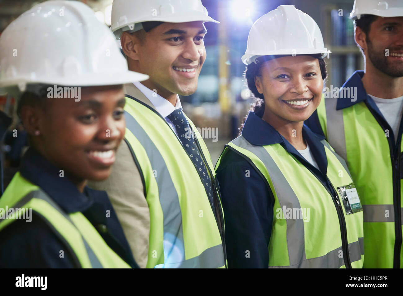 Ritratto fiducioso lavoratore di sesso femminile che con i colleghi di lavoro nel magazzino di distribuzione Foto Stock