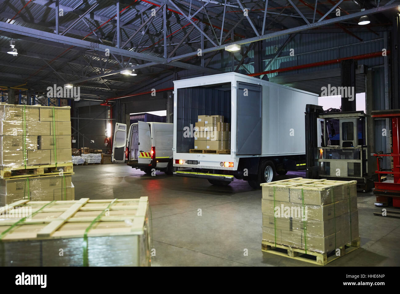 I carrelli e la scatola di cartone pallet a magazzino di distribuzione per dock di caricamento Foto Stock