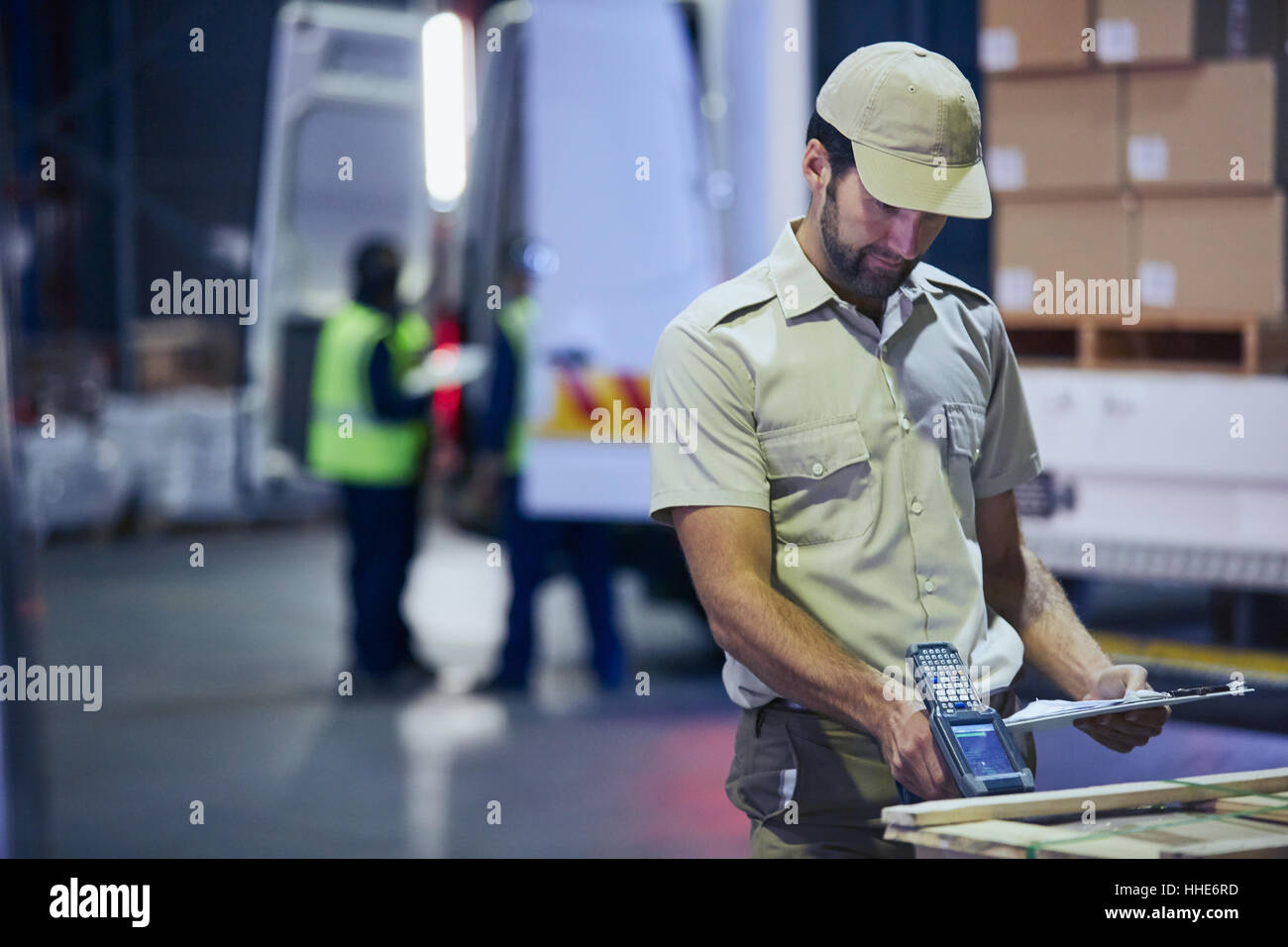 Camionista lavoratore pallet di scansione a magazzino di distribuzione per dock di caricamento Foto Stock