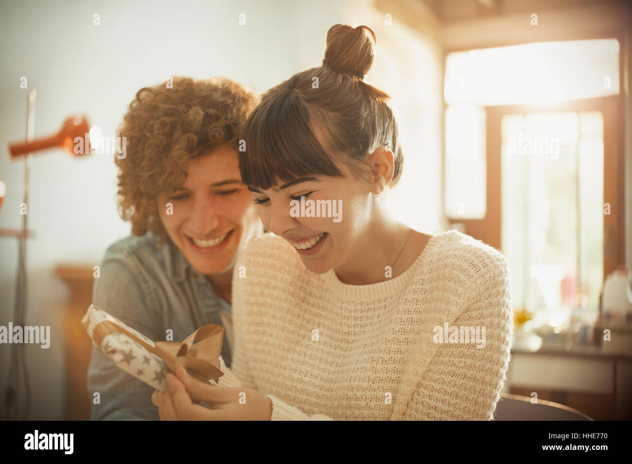 Sorridente coppia giovane apertura regalo di compleanno Foto Stock