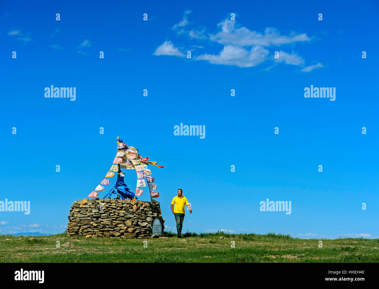 Il mongolo uomo esecuzione rituale di preghiera accanto ovoo, pietra sacra heap, Arkhangai, Mongolia Foto Stock