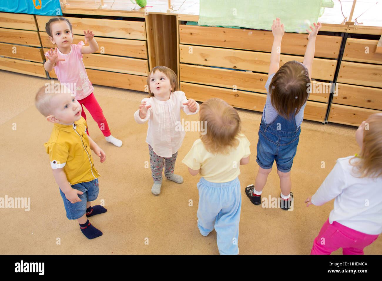 Bambini che giocano con le bolle di sapone in una scuola materna Foto Stock