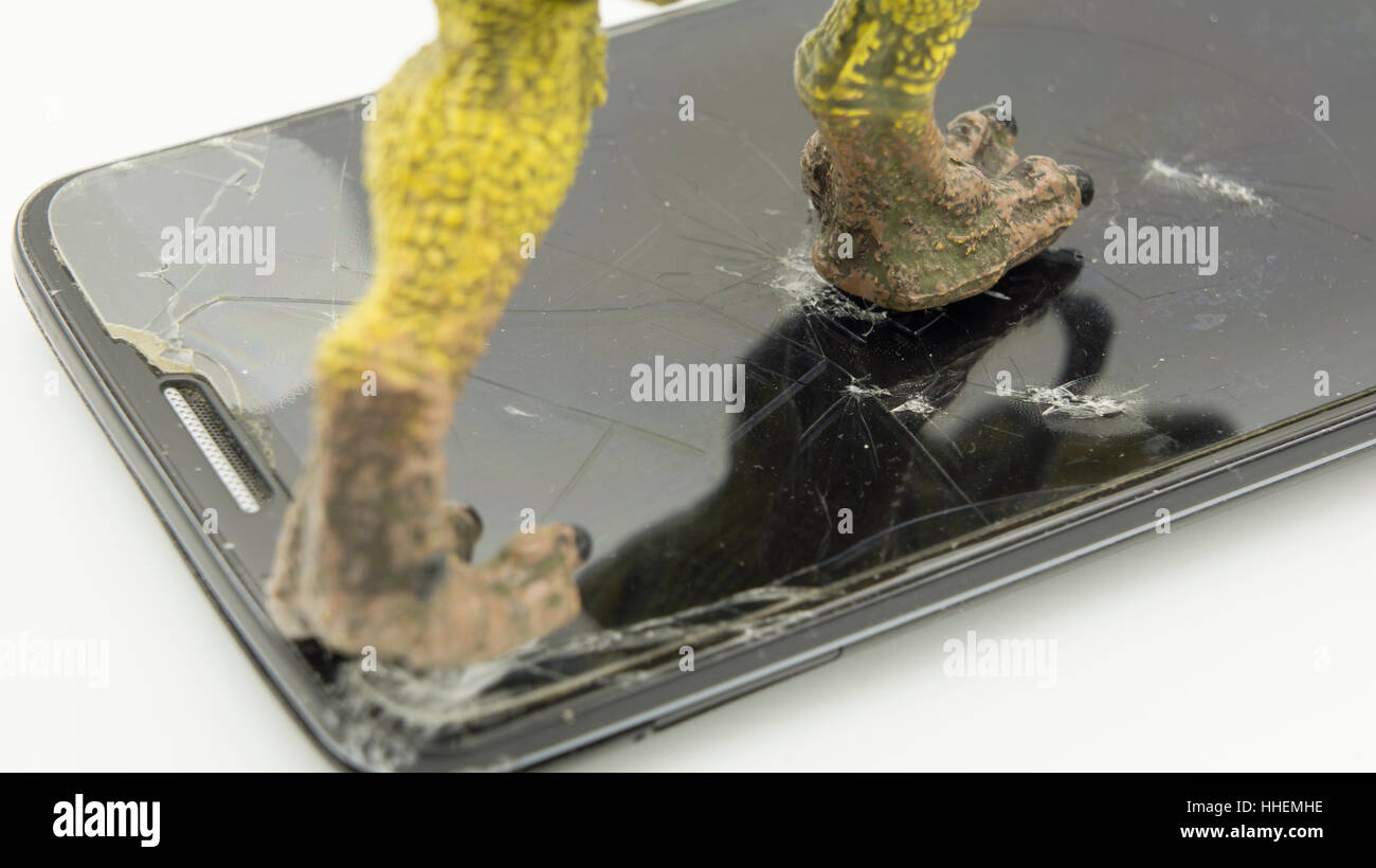 Dinosauro giocattolo rafforzamento sul telefono rotto Foto Stock